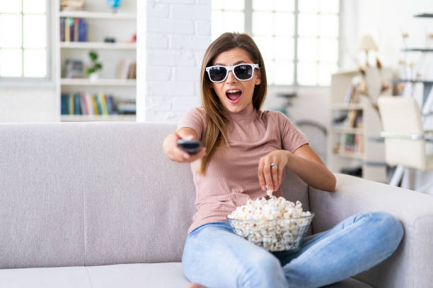 Amazed woman watching  a 3-D television at home